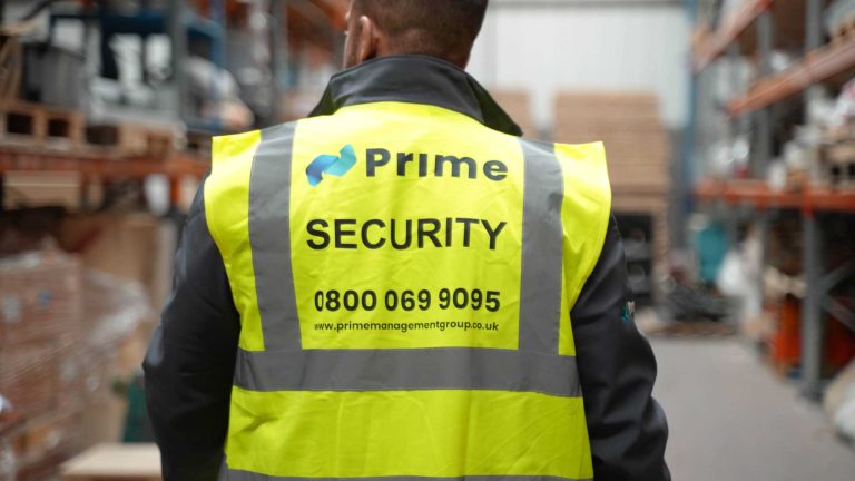 a security guard patrolling the inside of a warehouse, ensuring the site is safe.